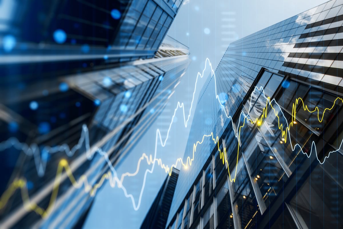 Double exposure image of skyscrapers with overlay of financial graphs