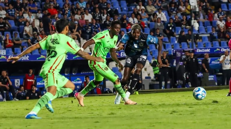 Soccer players in bright green jerseys and black jersey competing for the ball on a grass field during a match with spectators in the background