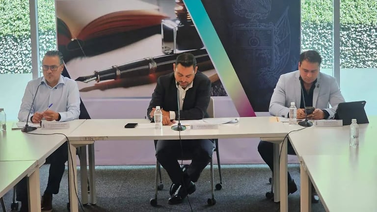 Three men seated at a panel table during a professional event or conference presentation