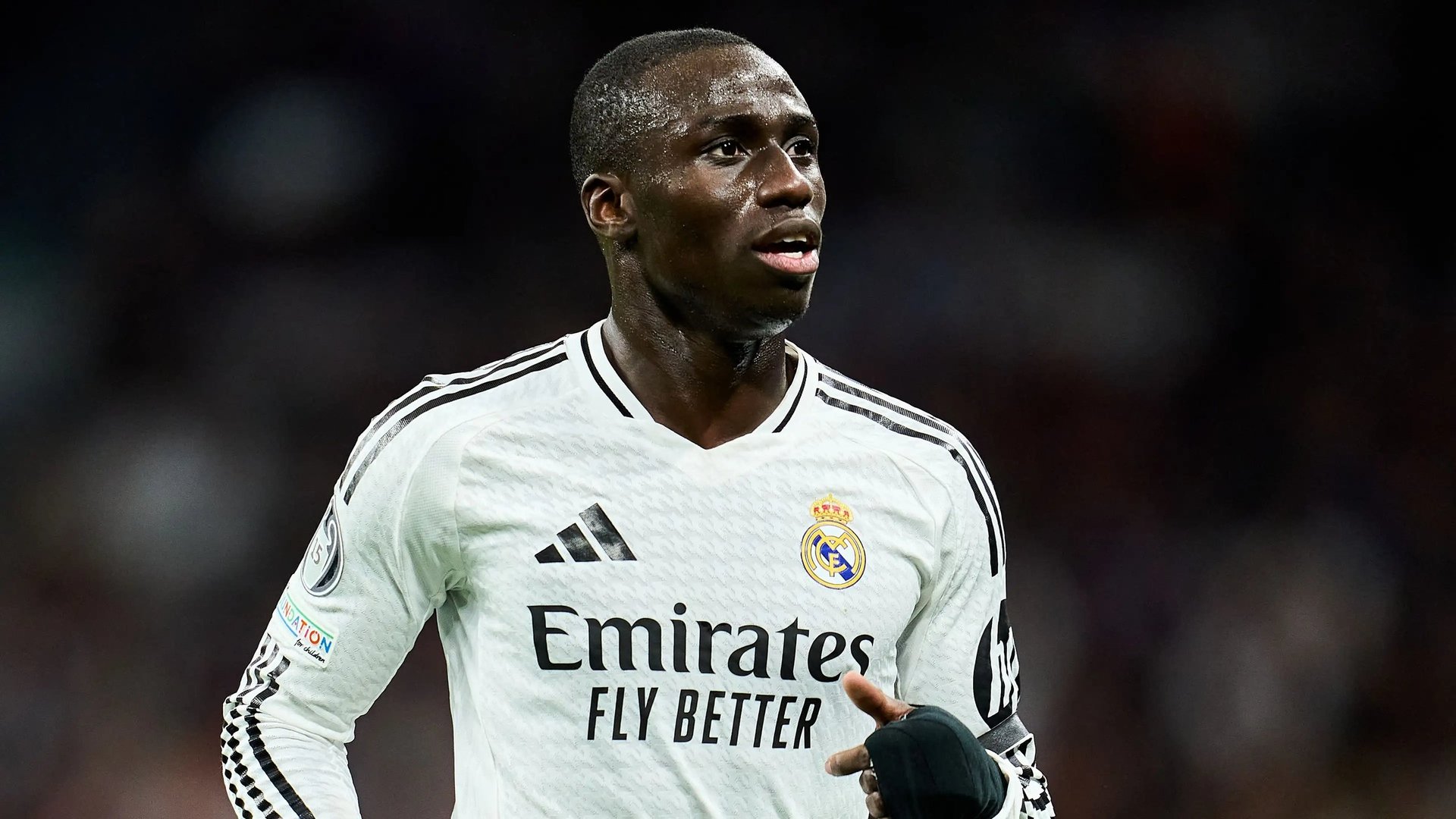 Professional footballer wearing Real Madrid white jersey with Adidas and Emirates sponsorships during match